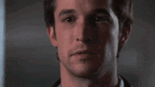 a close up of a man 's face in a dark room looking at the camera .