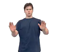 a man wearing a blue shirt is making a stop sign