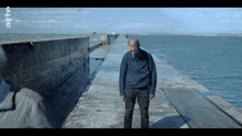a man stands on a dock with the letters rt on the bottom