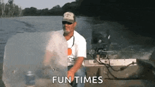 a man is sitting on a boat in the water with the words `` fun times '' written on the screen .