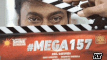 a close up of a person holding a clapper board that says mega157