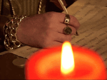 a person with a ring on their finger writes on a piece of paper