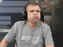 a man wearing headphones and a gfuel energy formula t-shirt