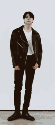 a man wearing a black leather jacket and black pants
