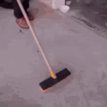 a woman is sweeping the floor in a garage with a broom .