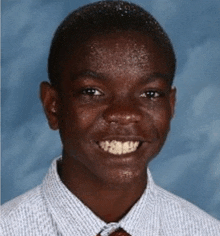 a young man wearing a striped shirt and tie smiles for the camera .
