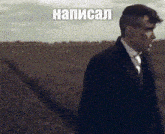a man in a suit and tie is standing in a field with the word napisal on the bottom