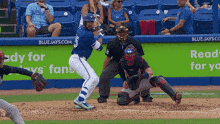 a blue jays player swings his bat at a ball