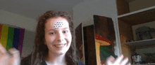 a young girl with googly eyes on her forehead is smiling