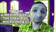 a man in a green plaid shirt with the words ta com medinho de destruir o microondas below him