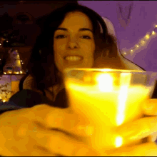 a woman is holding a lit candle in her hand
