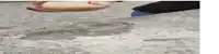 a person is standing on a concrete surface with their foot on a puddle .