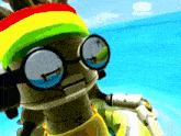 a robot wearing sunglasses and a rasta hat is standing on a beach