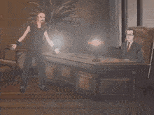a cartoon of a man standing next to a man in a suit sitting at a desk