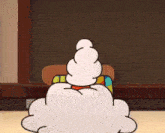 a cartoon character sitting in front of a chalkboard
