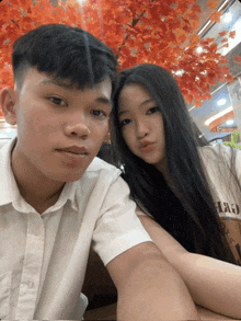 a boy and a girl are posing for a picture and the girl is wearing a shirt that says ' a '