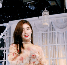 a woman in a floral dress stands in front of a bird cage