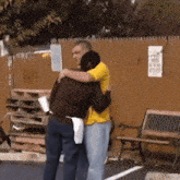 a man and a woman hugging each other in a parking lot .