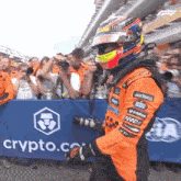 a man in a helmet stands in front of a sign that says crypto