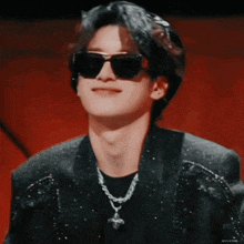a close up of a man wearing sunglasses and a chain