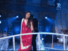 a woman in a red dress is on a stage in front of a zee tv sign