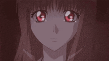 a close up of a girl 's face with red eyes and long hair .