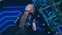 a woman with blue hair is dancing on a stage