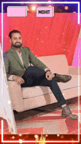 a man in a green jacket sits on a couch with his legs crossed and the name mohit on the bottom right