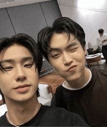 two young men are posing for a picture and one is making a face