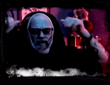 a man with a beard and glasses is wearing headphones and making a face .