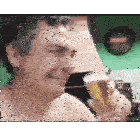 a man without a shirt is holding a glass of beer .
