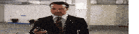 a man in a suit and tie looks at his phone