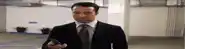 a man in a suit and tie looks at his phone