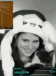 a black and white photo of a woman wearing a bunny hat and holding a cat