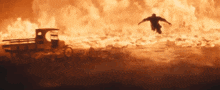 a man is flying through the air in front of a fire