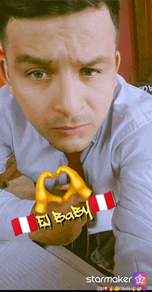 a man is making a heart shape with his hands and the word baby is on the bottom right