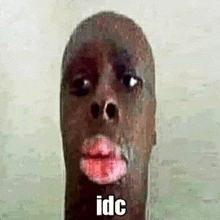 a close up of a man 's face with red lips and the words `` idc '' written on it .