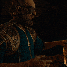 a man with a beard is wearing a blue sweater and holding coins on his face