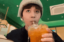 a person wearing a beanie drinking from a glass