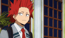 a boy with red hair and a backpack is standing in front of a window .