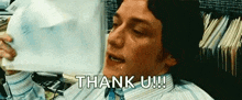 a man is crying while holding a piece of paper with the words `` thank u '' written on it .