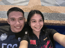 a man and a woman are taking a selfie in a pool with the man wearing a shirt that says ov yim