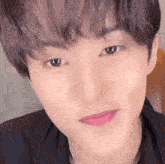 a close up of a young man 's face with a slight smile on his face