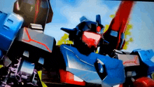 a blue robot with red eyes and a red stripe on its chest