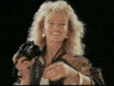 a woman is holding a camera and smiling in a pixelated image
