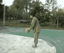 a person standing on a concrete surface holding a ball