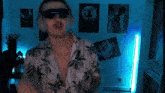 a man wearing sunglasses and headphones is dancing in a room with posters on the wall