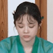 a close up of a woman wearing a green kimono .