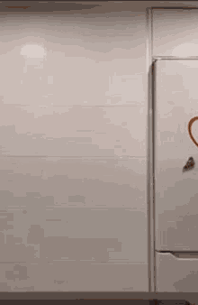 a shirtless man is standing in front of a refrigerator with a red heart drawn on it .