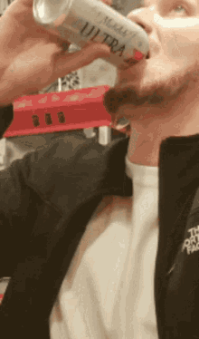 a man is drinking a can of miller lite ultra